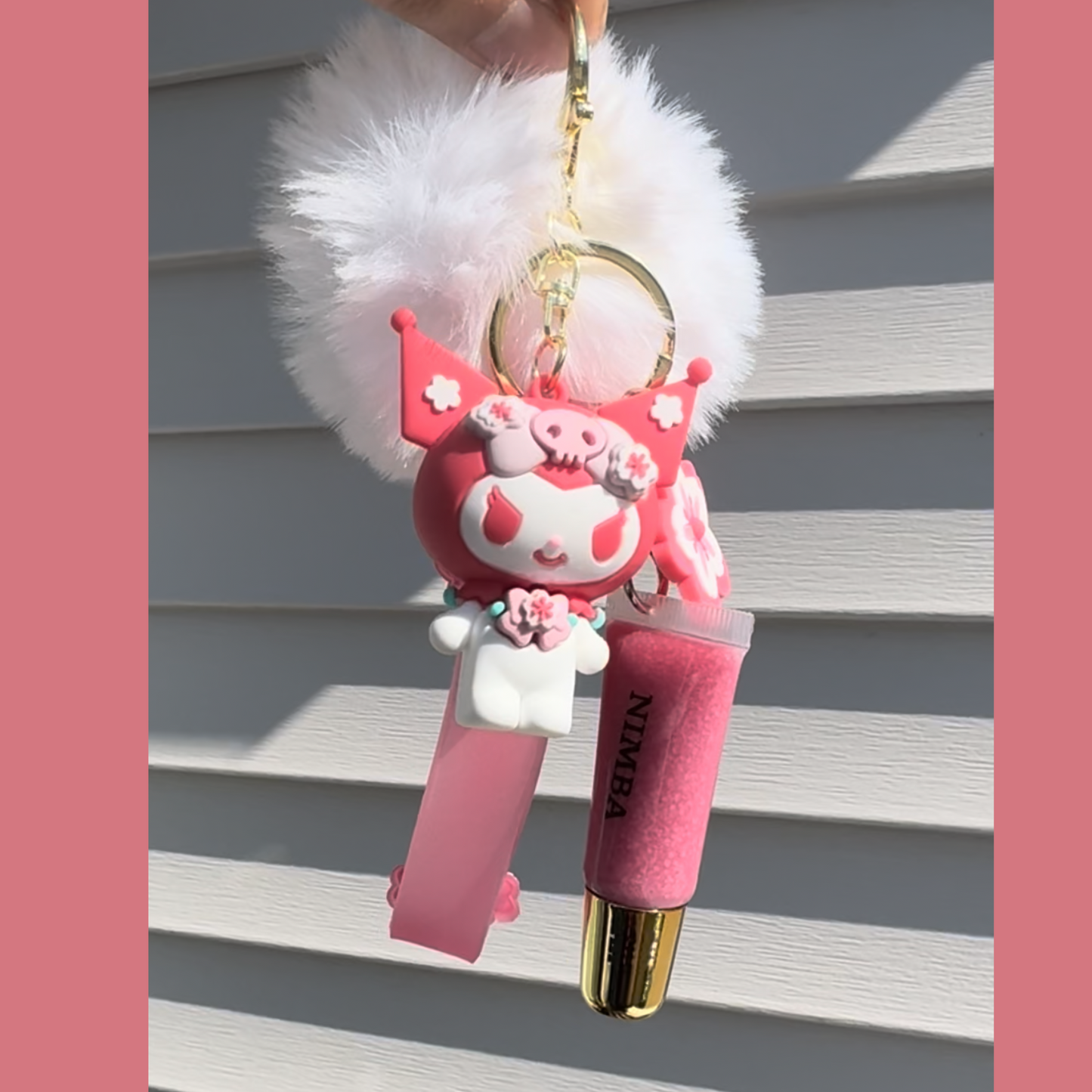 NIMBA pink lip butter with a cherry blossom-themed keychain and white pom-pom, designed for hydrating, natural lip care