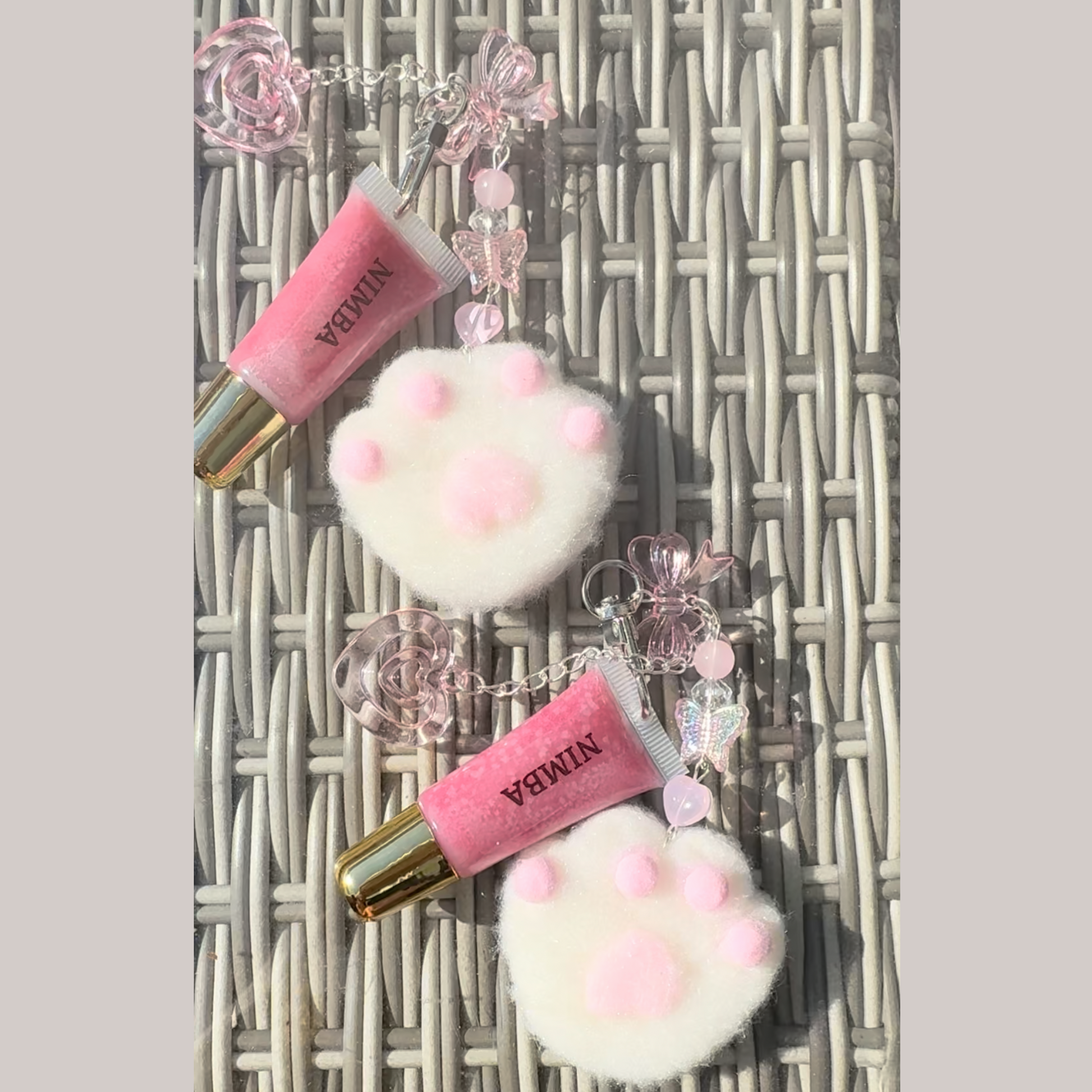 NIMBA lip butter keychain with a fluffy white paw print charm, ideal for travel-friendly lip care and gifting